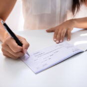 Business person signing a cheque with a pen