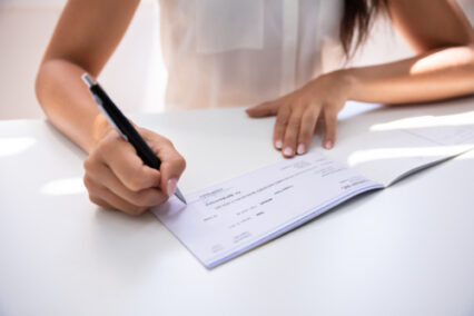 Business person signing a cheque with a pen