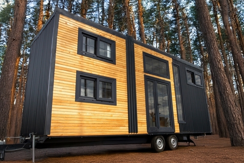 Modern tiny house on wheels with wooden exterior.