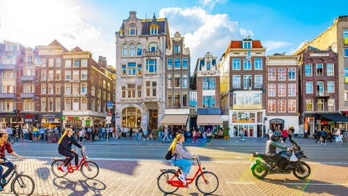Damrak street in central Amsterdam, people cycling