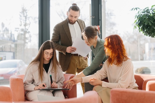 A team of diverse business people discussing work, planning strategy and collaboration in a modern office lounge