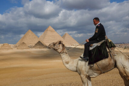 A Police officer rides his camel in Giza Pyramids area.