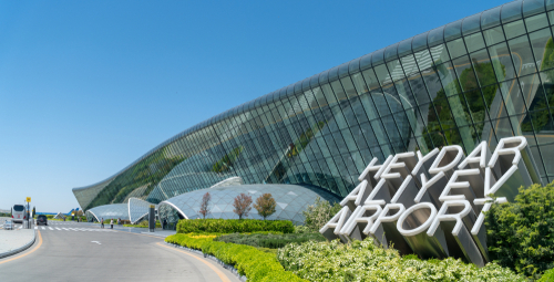The sign of Heydar Aliyev Airport next to its main Terminal