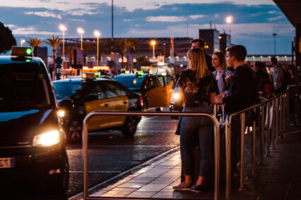 Colorful dusk with Tourists and visitors of Barcelona waiting for the taxi car in queue in front of the El Prat Barcelona international airport