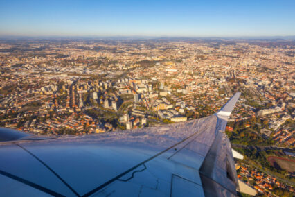 Top view of Porto and wing of airplane from window of airplane just take off from Oporto international airport, Porto city, Portugal