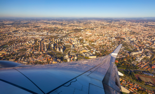 Top view of Porto and wing of airplane from window of airplane just take off from Oporto international airport, Porto city, Portugal