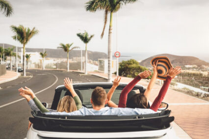 Happy friends having fun in convertible car on vacation