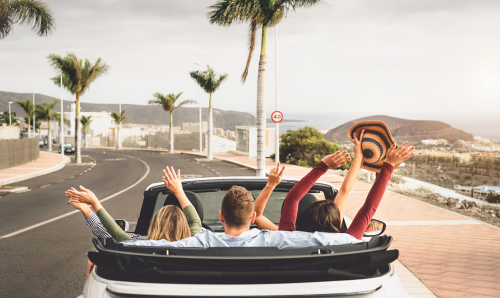 Happy friends having fun in convertible car on vacation