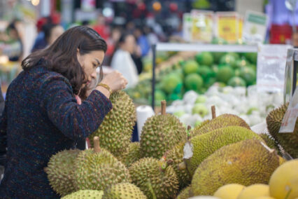 Vietnamese young Woman buying durian while shopping in supermarket,
