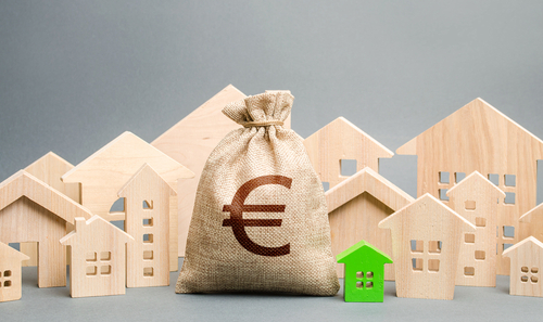 Euro money bag and a city of house figures. Buying real estate, fair price.