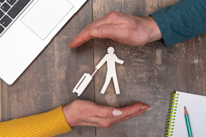 Concept of travel insurance with hands in a protective gesture