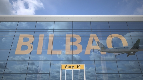 Airliner reflecting in the windows of airport terminal with Bilbao text 3D rendering