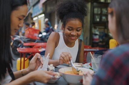 Group of young ladies eating local food in Thailand.