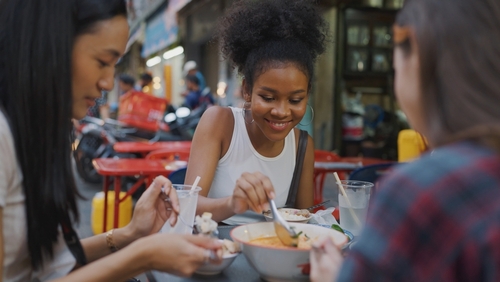 Group of young ladies eating local food in Thailand.