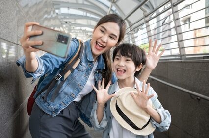 Portrait Of Happy mother Enjoy selfie With Luggage At Airport