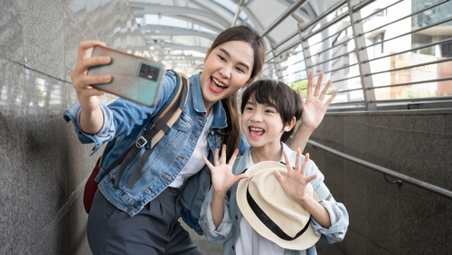 Portrait Of Happy mother Enjoy selfie With Luggage At Airport