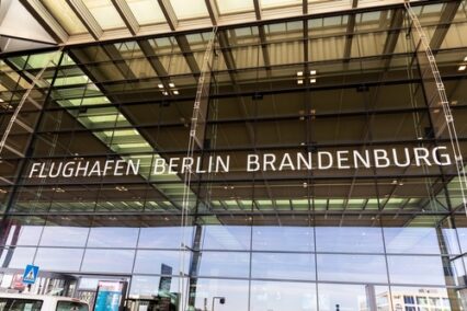 Glass modern facade entrance view Berlin Brandenburg airport logo outdoors new terminal building.