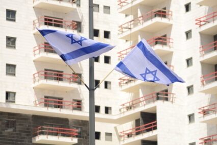 Modern apartment buildings and the flag of Israel.