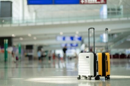 Two suitcases in an empty airport hall, traveler cases in the departure airport terminal waiting for the area