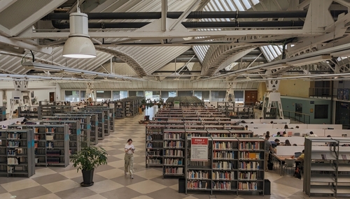 Inside the library of Pablo de Olavide university - looking down from above - on the right students studying at tables