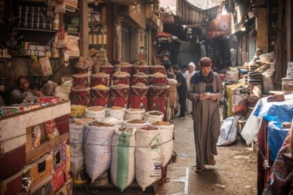 An Egyptian man walking in the narrow streets of the spice market a busy souk popular with locals and tourists near Khan El Khalili Bazaar, Al Hussein, Cairo, Egypt.
