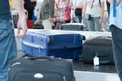 suitcases on baggage carousel at an airport on a busy travel day