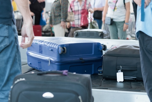 suitcases on baggage carousel at an airport on a busy travel day