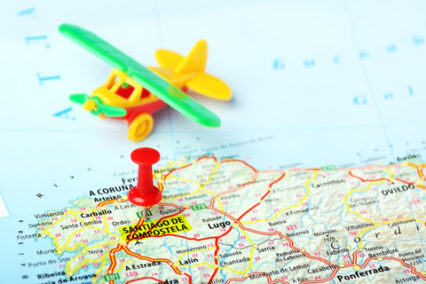 Map with a pin showing Santiago de Compostela, Spain and airplane toy