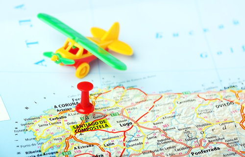 Map with a pin showing Santiago de Compostela, Spain and airplane toy
