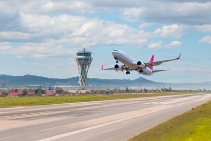 White passenger plane takes off from the runway of the airport - El Prat-Barcelona airport.