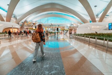 Female traveler walking through the expansive hall of a modern airport terminal