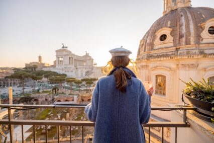 A woman enjoying the view of Altare della Patria and historic dome in the background