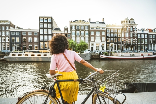 Happy female tourist visiting Amsterdam city, Netherlands
