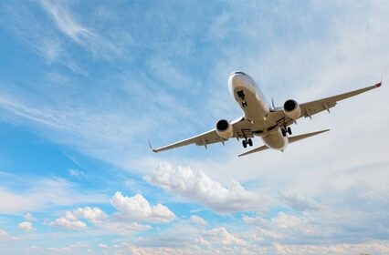 Airplane taking off from airport - White commercial airplane flying over city and lake
