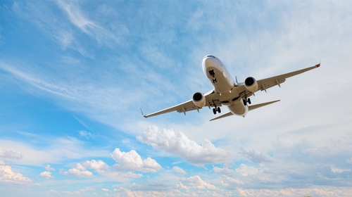 Airplane taking off from airport - White commercial airplane flying over city and lake
