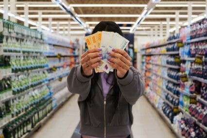 girl holding Argentine peso bills in the supermarket.
