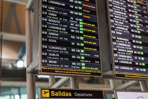 Airport departure board displaying flight information at Madrid Barajas International Airport in Madrid