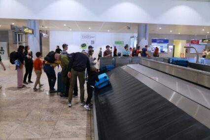 Passengers wait at baggage conveyor belt at Alicante Airport in Spain.