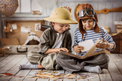 Two boys in the form of tourists and a pilot looking at pictures from his travels