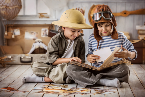 Two boys in the form of tourists and a pilot looking at pictures from his travels