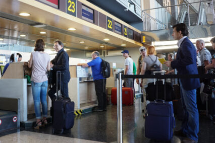 Airline passengers checking in at an airline counter in the Valencia Airport.