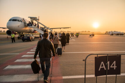 Passengers line up for boarding next to airplane at the Liszt Ferenc airport.