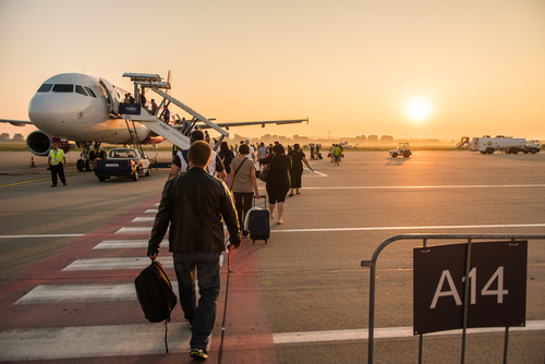 Passengers line up for boarding next to airplane at the Liszt Ferenc airport.