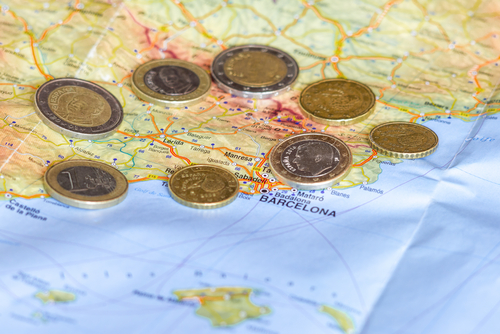 Spainish Euro coins are seen over map of Catalonia region in Spain.