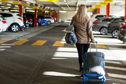 Girl with bag in airport parking lot