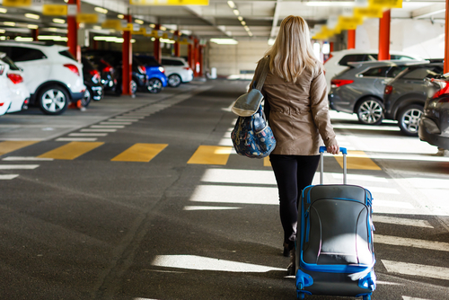 Girl with bag in airport parking lot