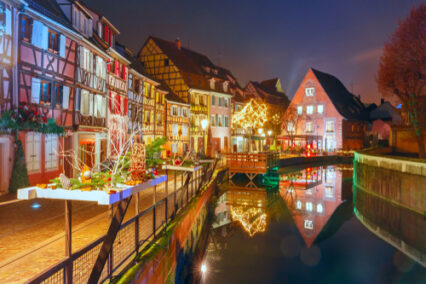 Traditional Alsatian half-timbered houses in Petite Venise or little Venice, old town of Colmar, decorated and illuminated at snowy christmas night, Alsace, France