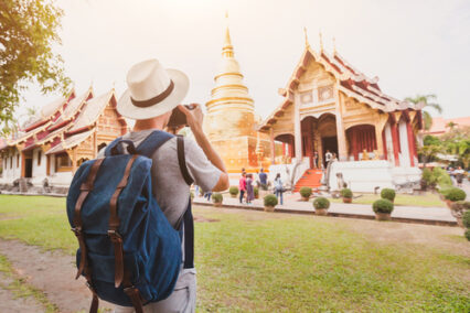 Tourist photographer taking photo of temple or landmark, tourism in Thailand
