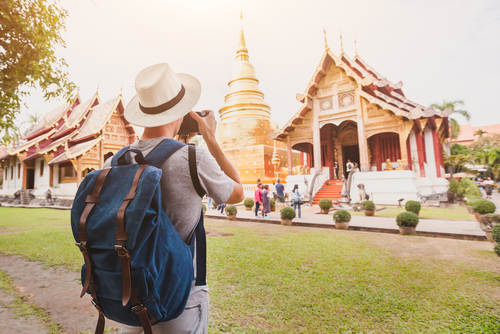 Tourist photographer taking photo of temple or landmark, tourism in Thailand
