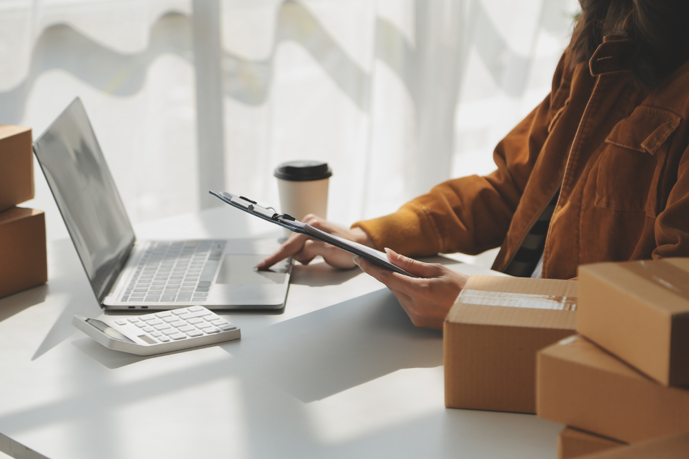freelancer with a laptop, calculator and notepad nearby